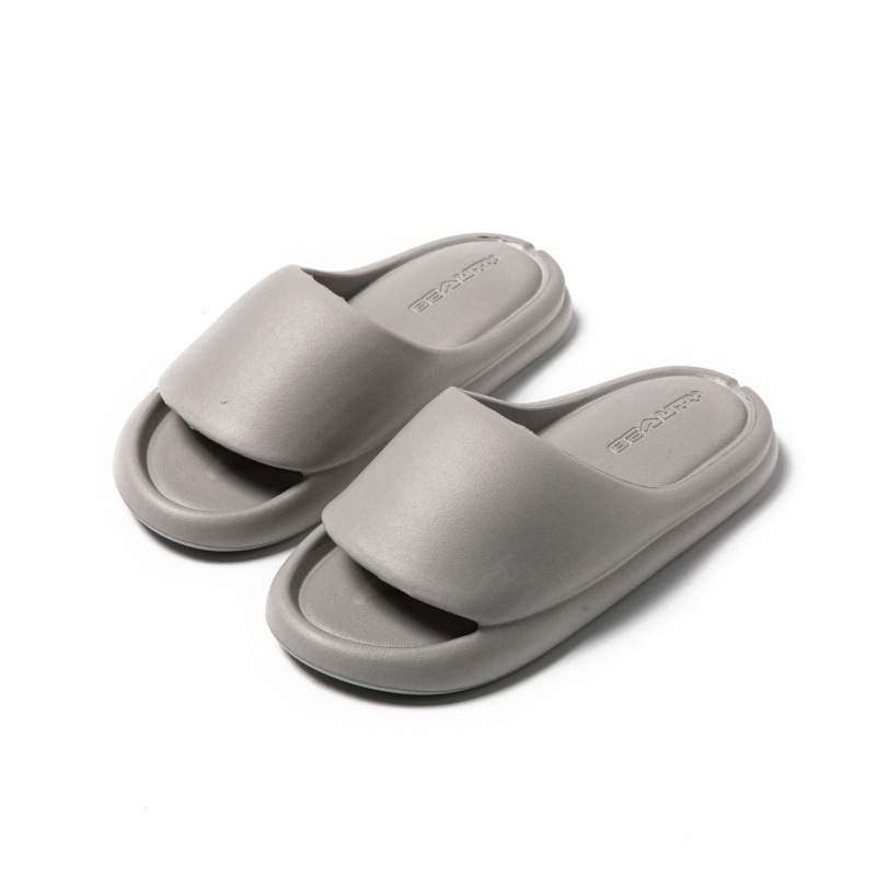 A pair of gray EVA slides with a curved sole design, placed on a white background.